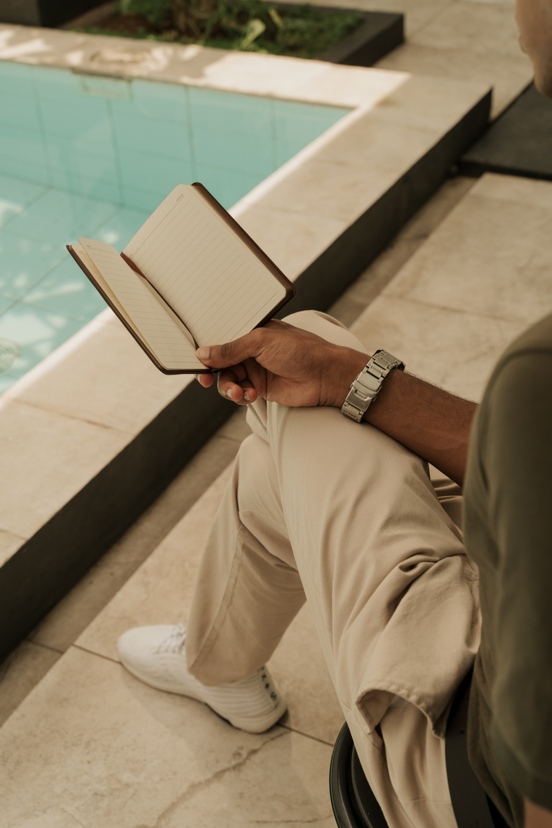 Man Reading a Book by the Swimming Pool
